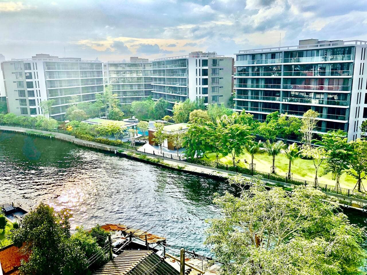 Landscaped gardens and modern exterior of the Bangkok River Oasis complex