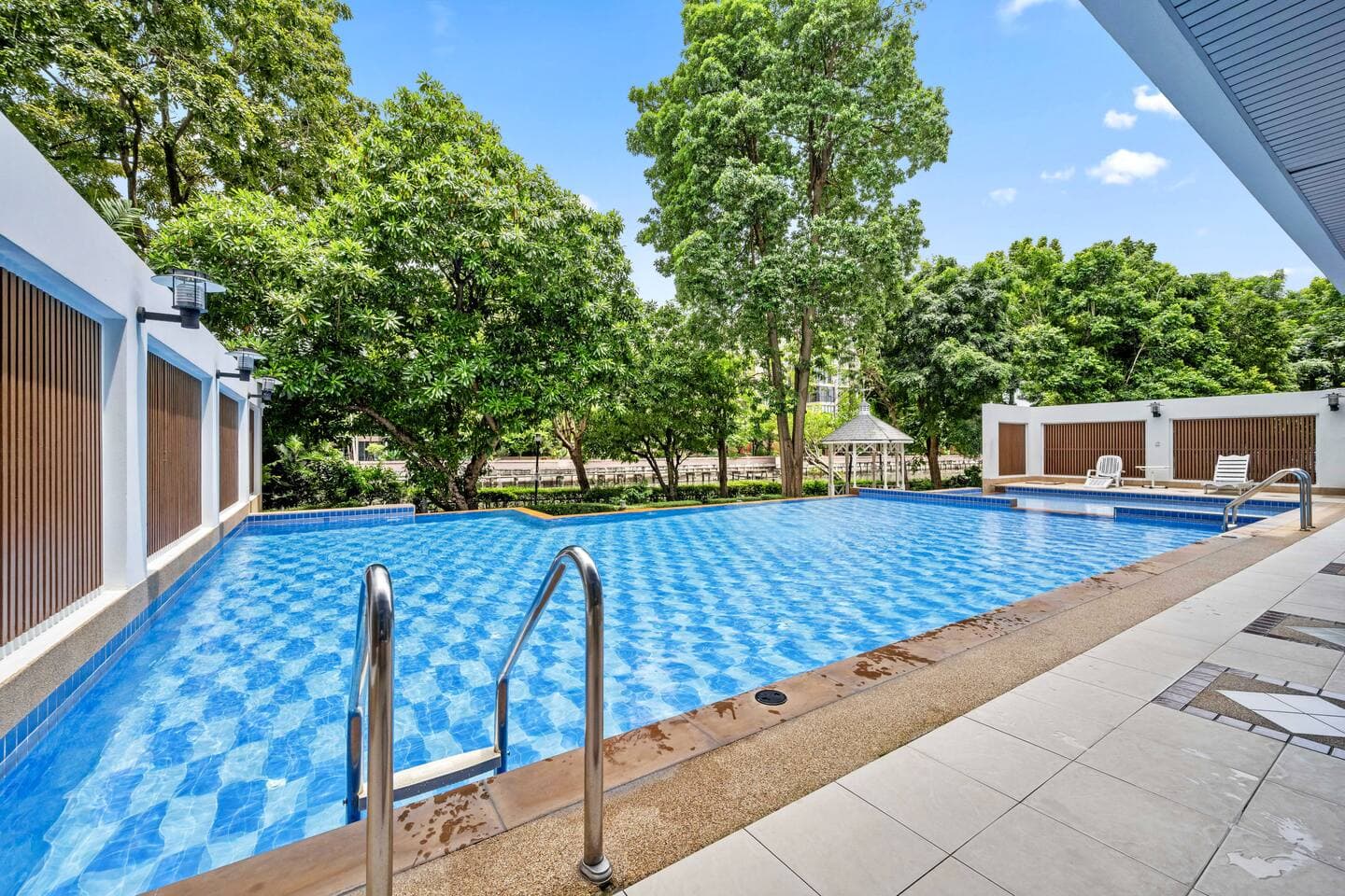 Large outdoor swimming pool surrounded by tropical landscaping