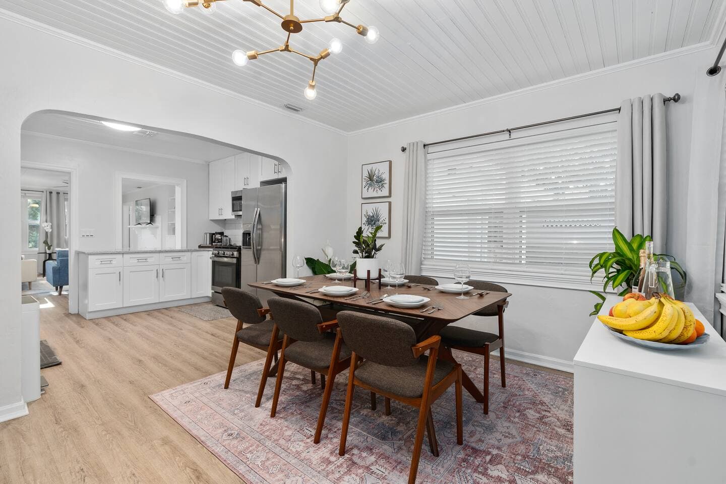 Elegant dining room featuring a wooden table and designer lighting – The Falling Moss Villa