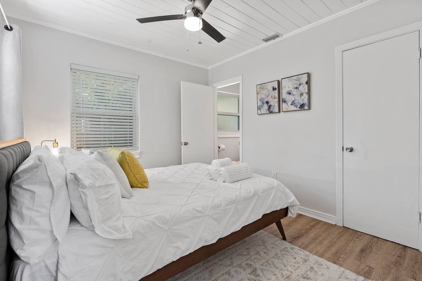 Airy guest room featuring a cozy queen bed and modern art – The Falling Moss Villa