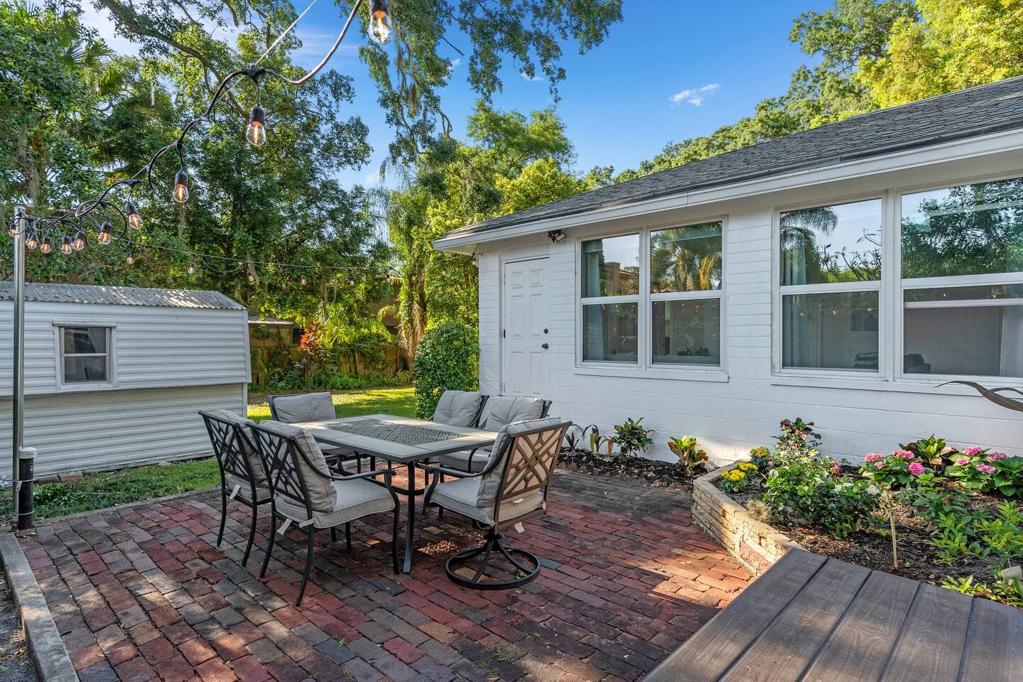 Rear view of the villa showing the spacious brick patio and outdoor dining