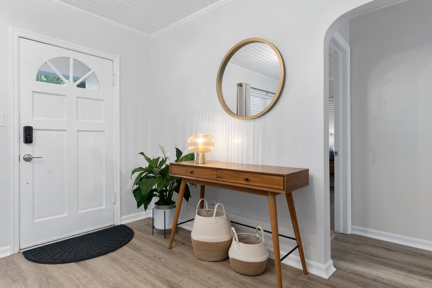 Modern entryway with round mirrors and wood console table