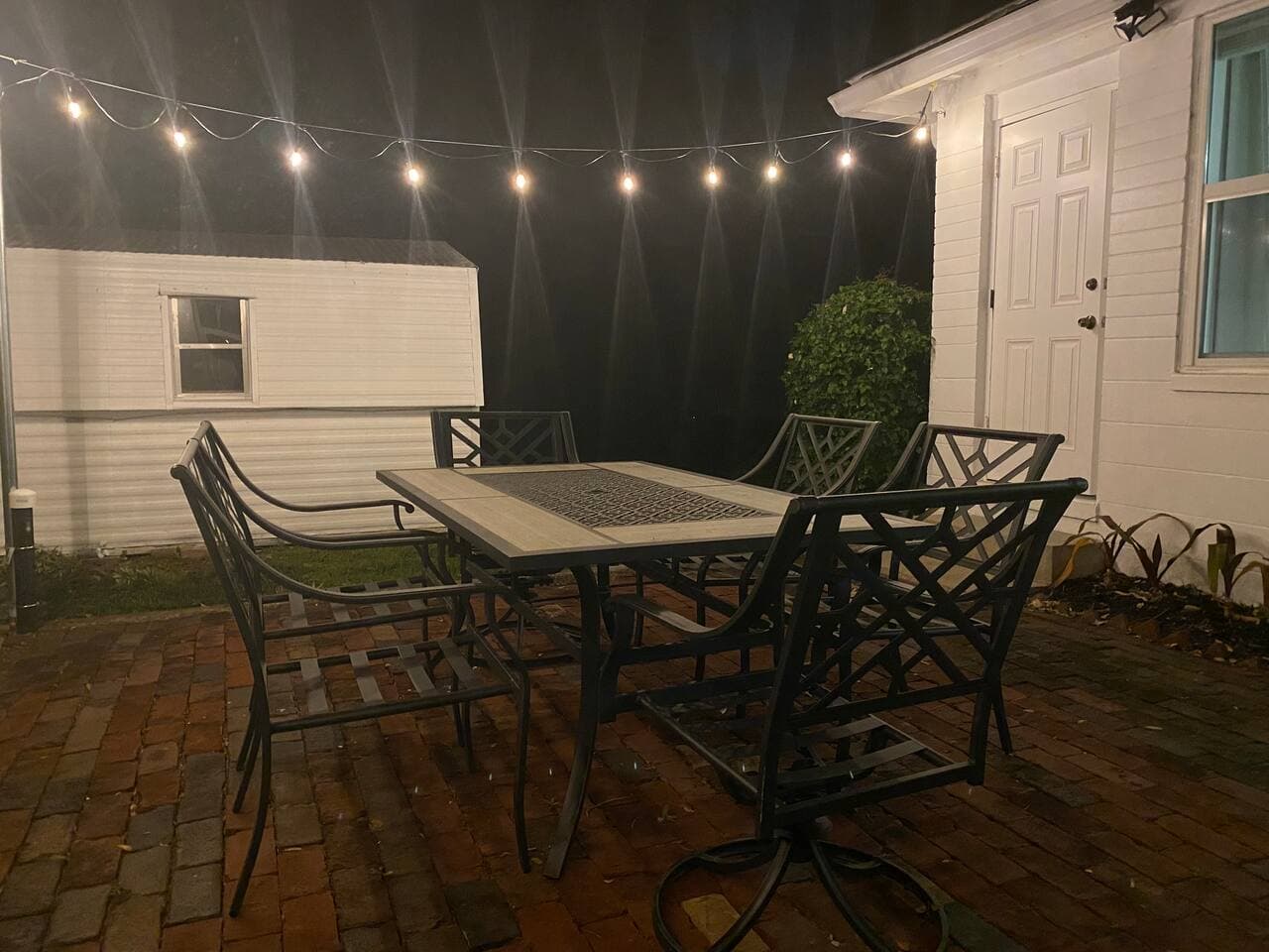 Outdoor dining area at night with romantic string lights – Falling Moss Villa