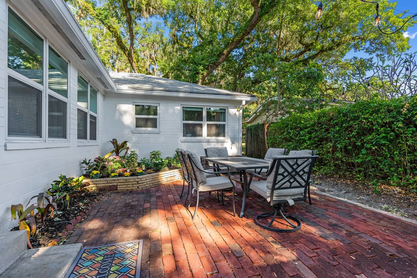 Private outdoor patio with seating area and surrounding garden