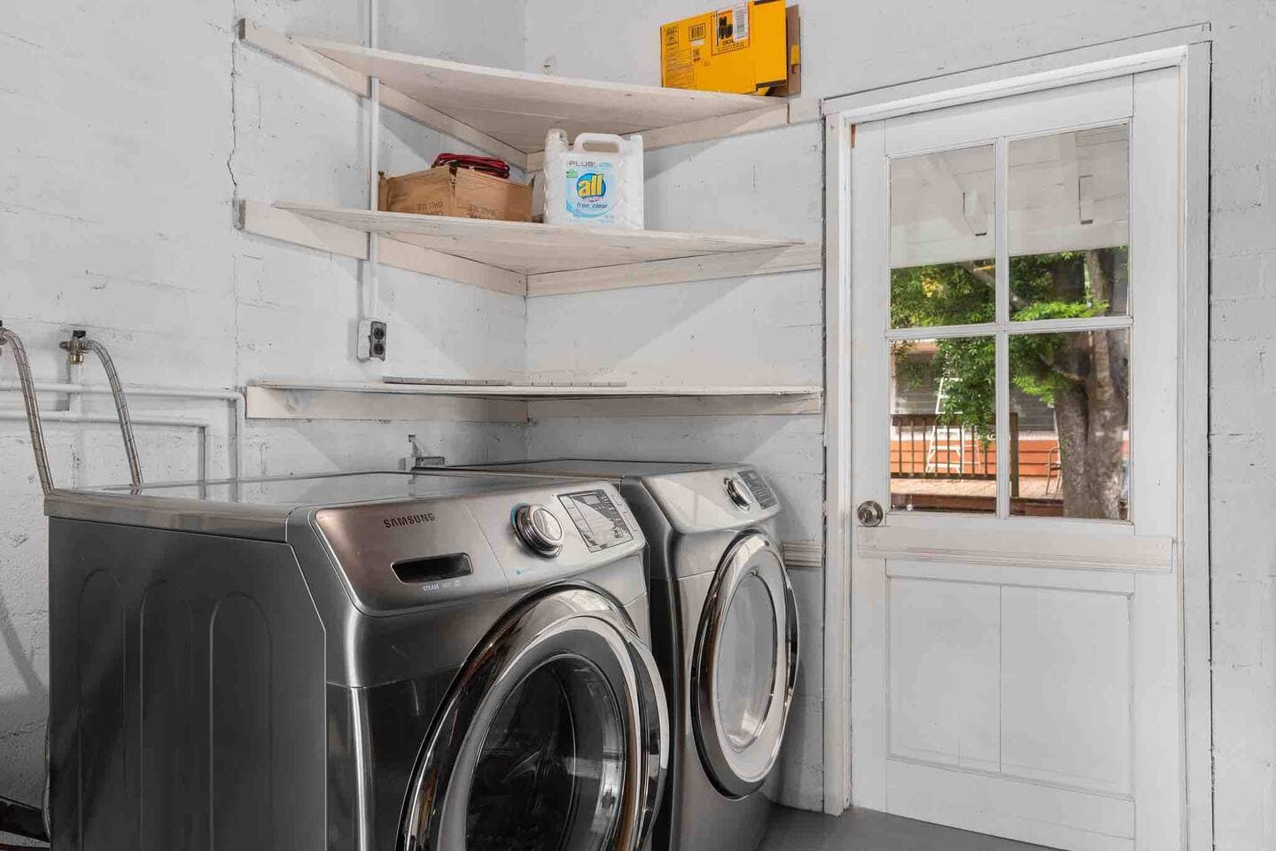 In-unit laundry room with washer, dryer, and storage – The Falling Moss Villa