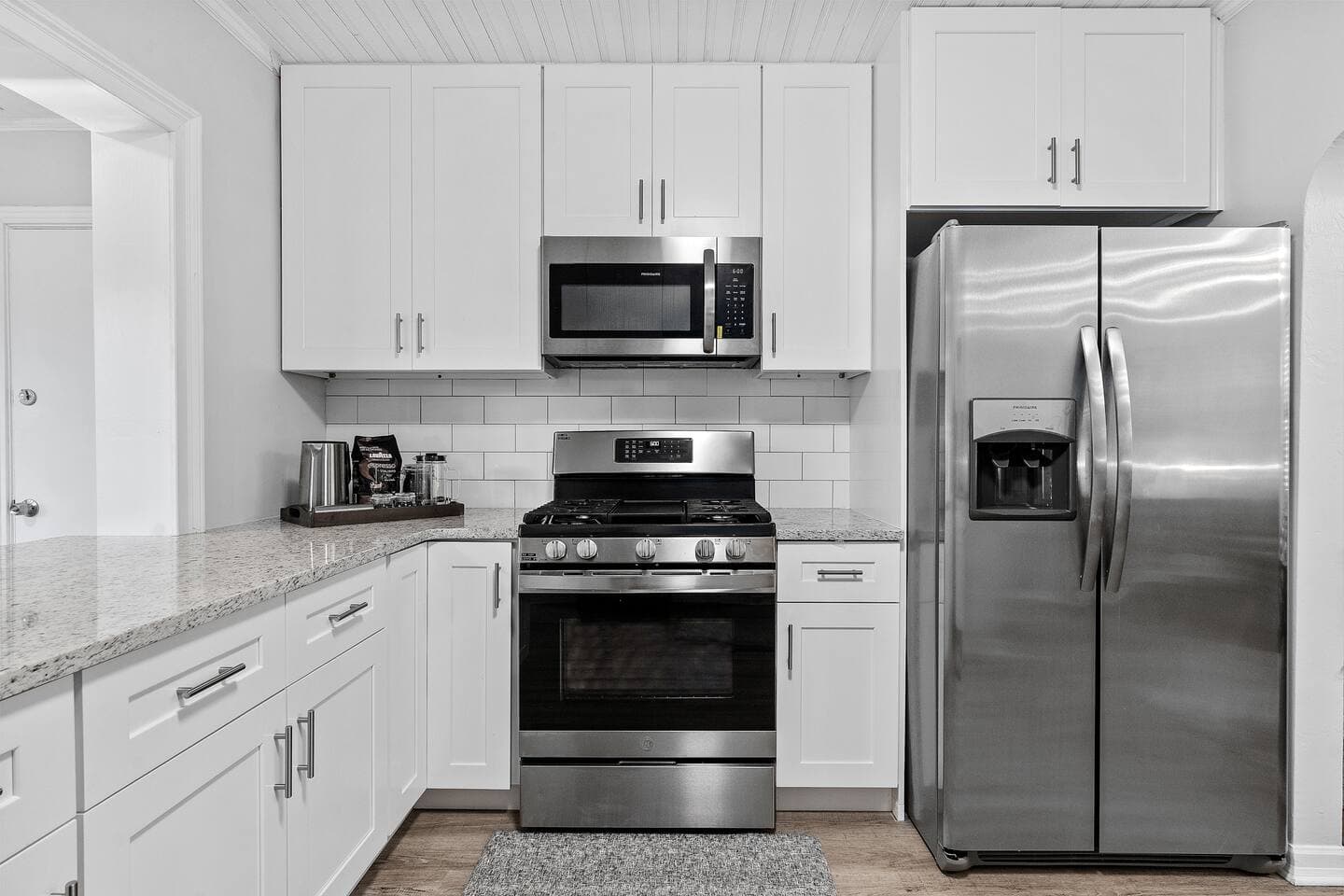 Modern kitchen with white cabinetry and stainless steel appliances – Falling Moss Villa